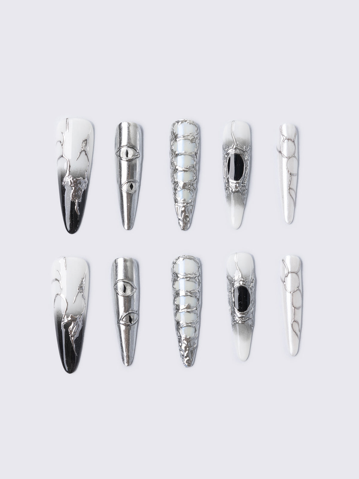 Press-on nail set in chrome and white with marble, piercing rings, chain lacing, and stiletto shape for a grunge glam look.