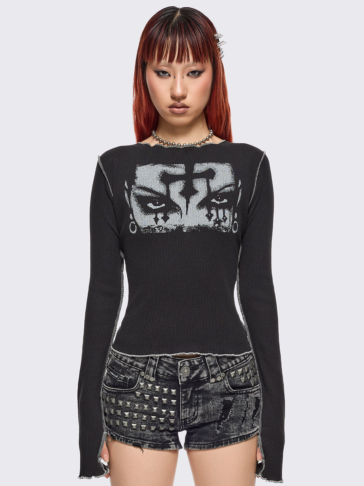 Black ribbed long sleeve top featuring a malefic eyes graphic front print, thumbhole cuffs and white reverse stitching.