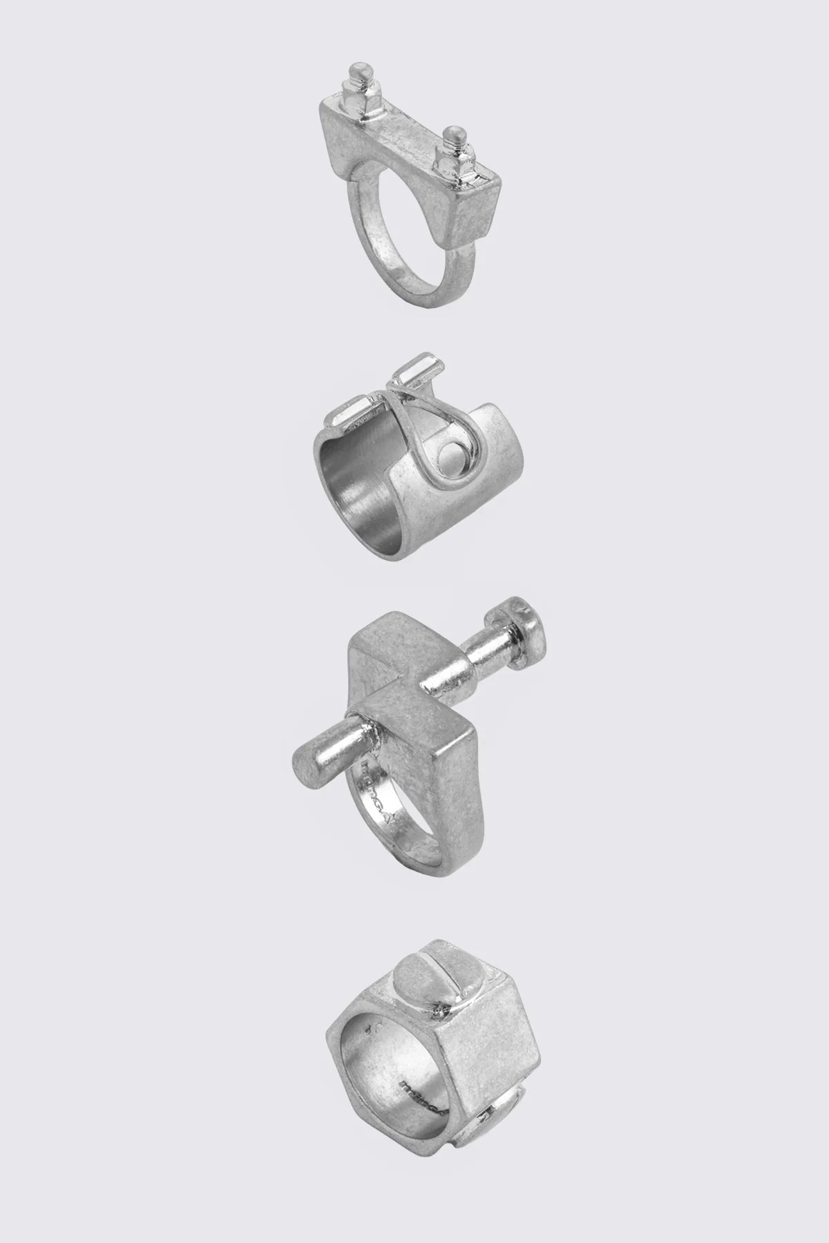 Silver zinc ring set with chunky hardware-inspired bands and oxidized finish in a grunge aesthetic.