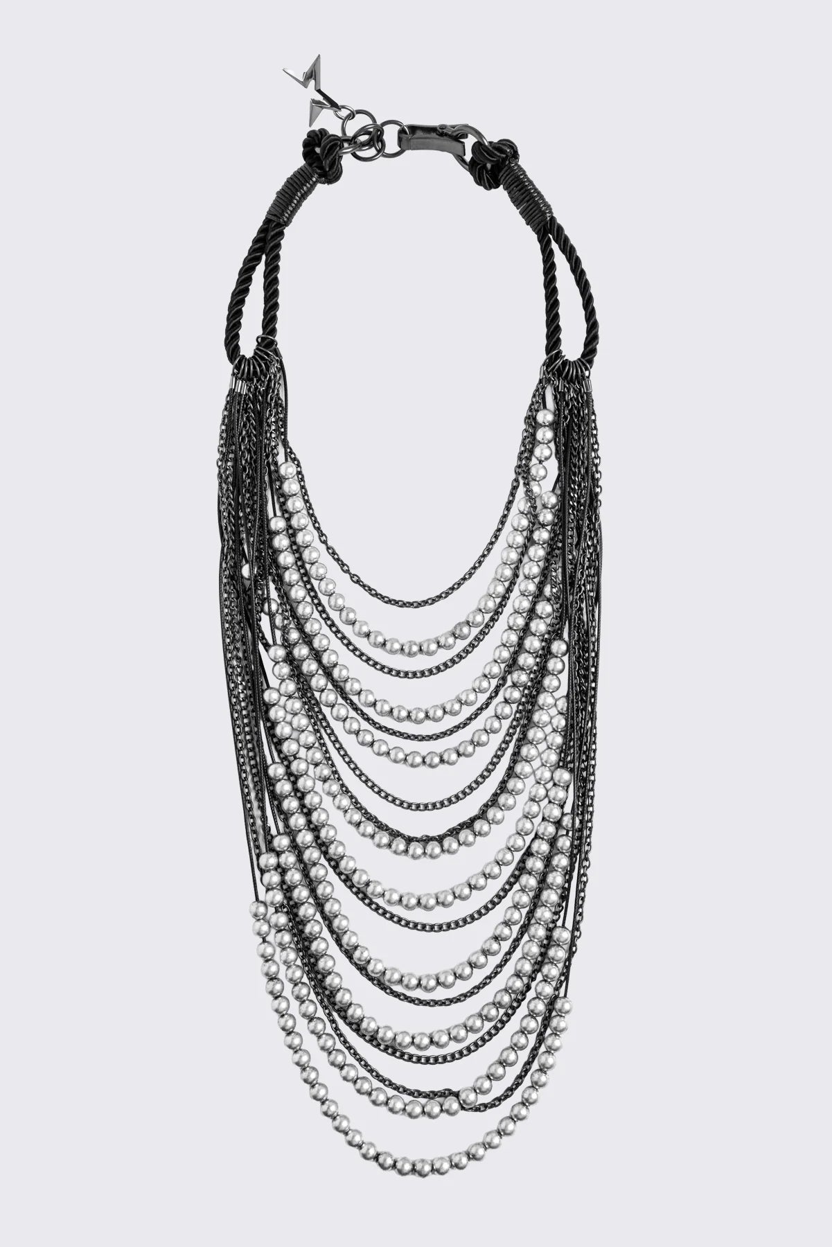 Silver layered chain necklace with beaded and curb chain strands, black knotted cord straps and charm pendant.
