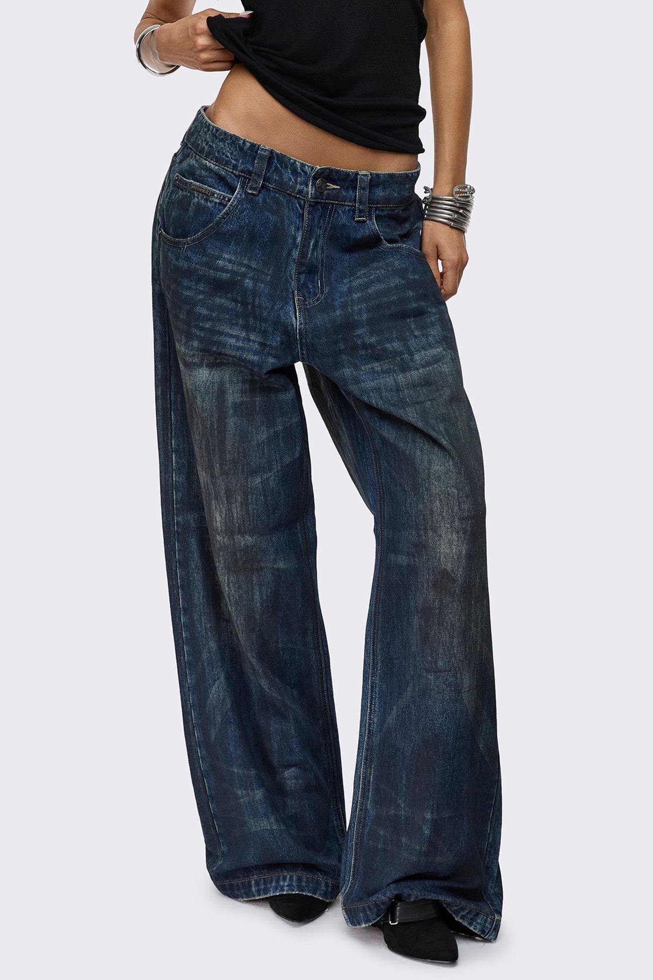 Indigo blue baggy wide leg jeans with dirty wash, whisker creases, regular waist and five-pocket design.