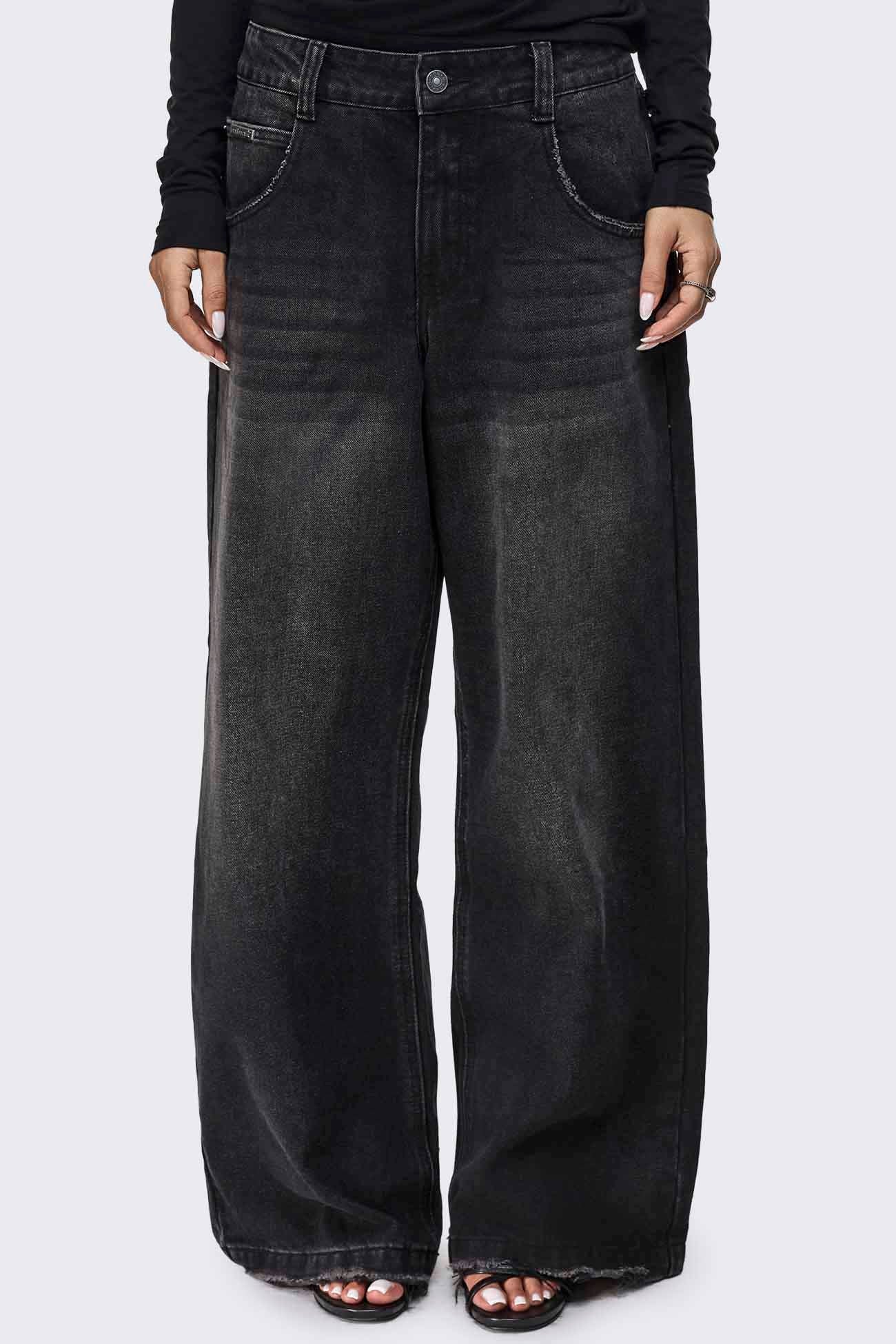 Black washed wide leg jeans with distressed details, raw frayed hem and relaxed fit.