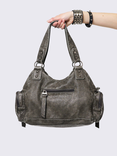 Grey washed faux leather shoulder bag with studded cross patches, spikes and chains accents. Multiple pockets and grunge-style.