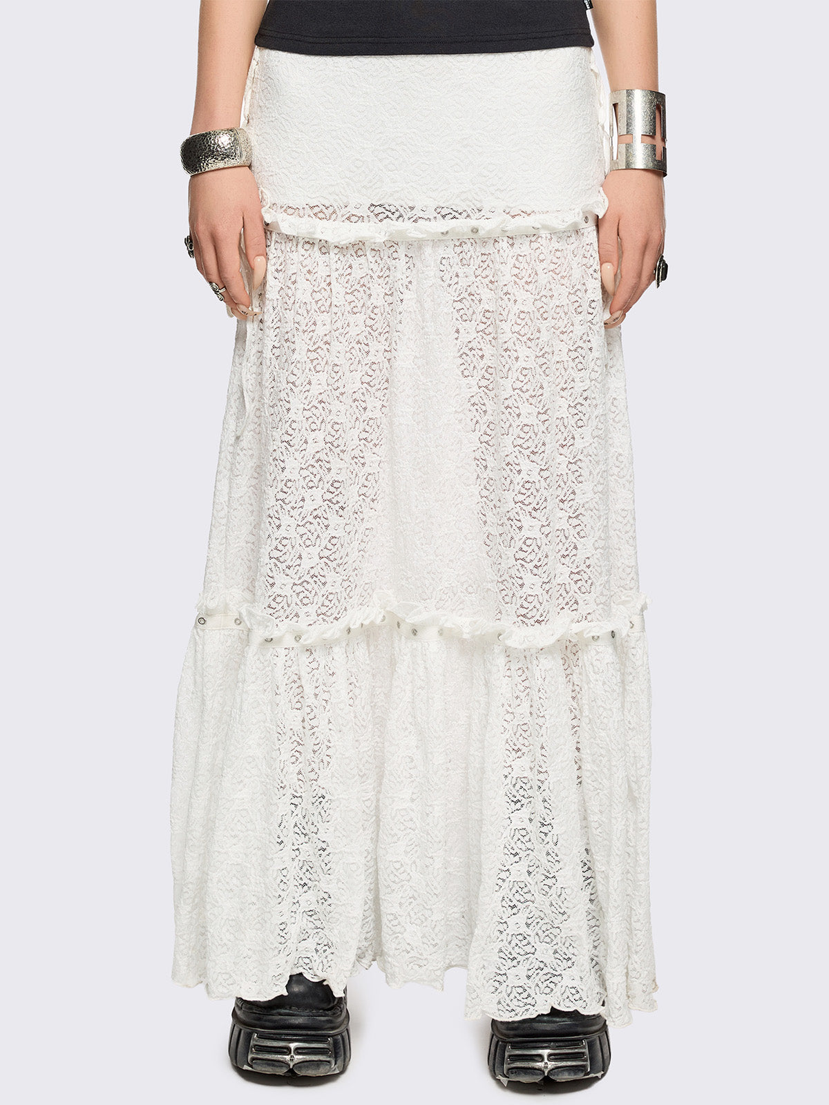 White floral lace maxi skirt with tiered lace layers with ruffles, lace-up sides with bow ties and eyelet trim details.