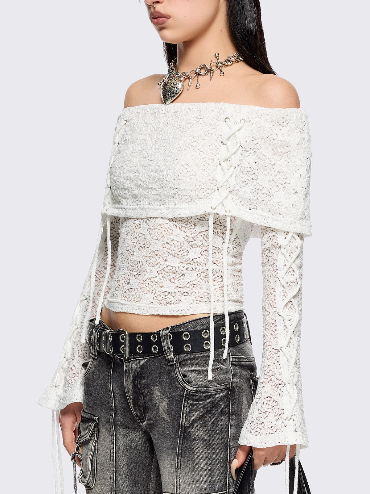 Off shoulder top in white lace construction. Bardot fold-over neck, lace up details and long flared sleeves.