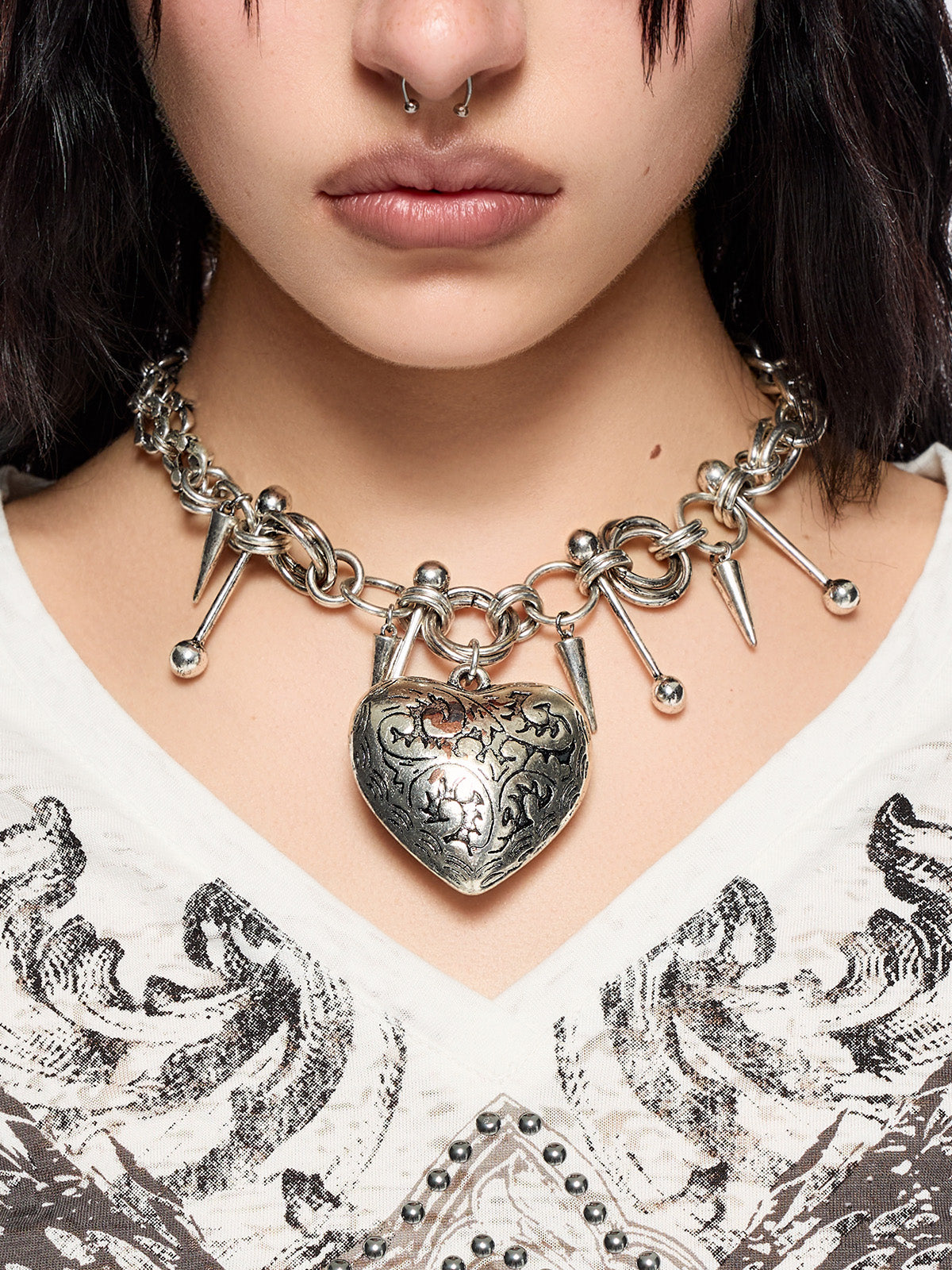 Silver chunky charm necklace with 3D heart pendant and bold metal piercing and spike details.