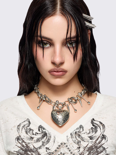 Silver chunky charm necklace with 3D heart pendant and bold metal piercing and spike details.