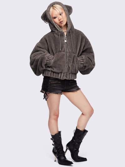 Brown oversize faux fur jacket with cat ear hood with piercing details.