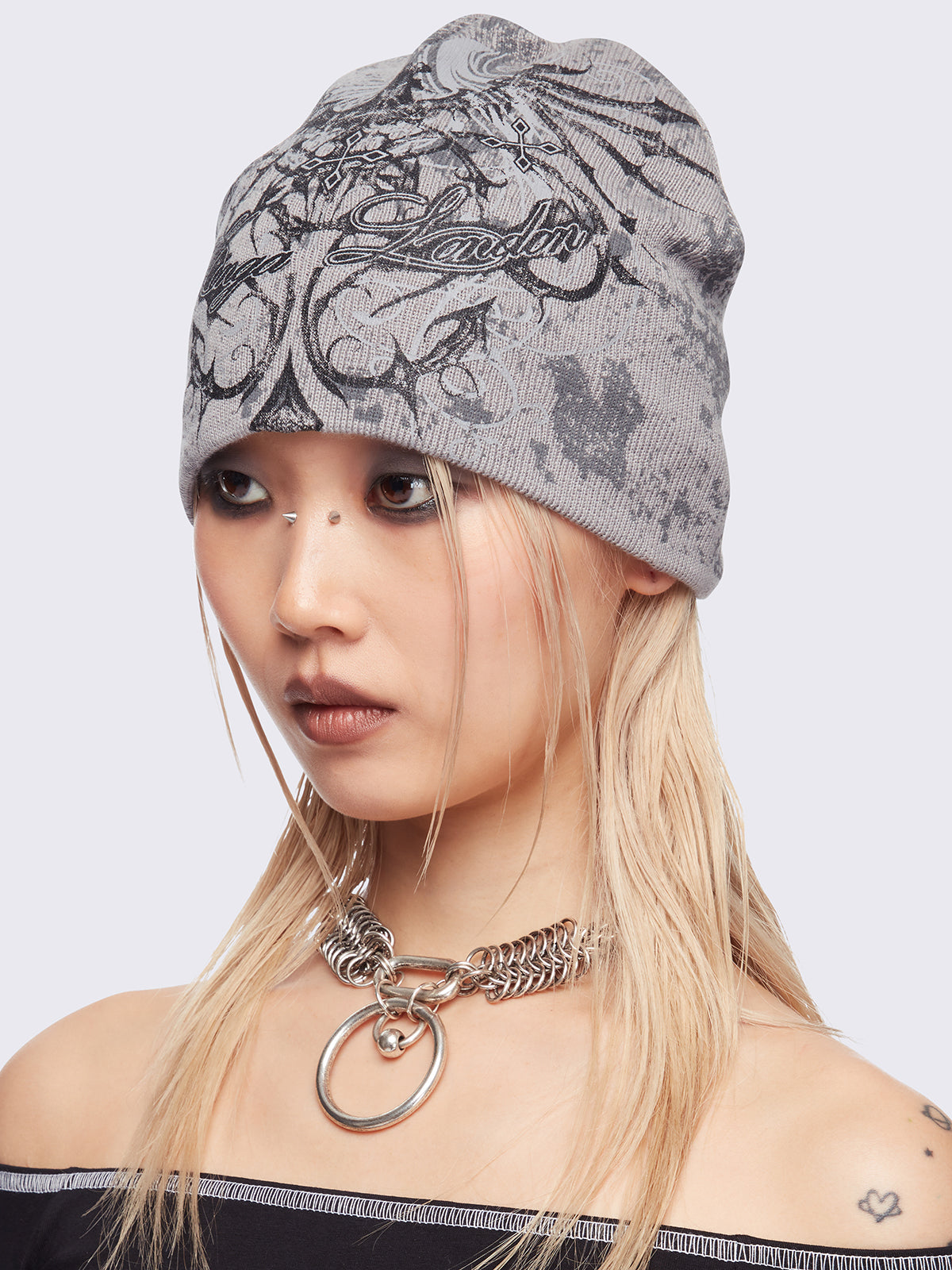 Grey beanie hat with grunge graphic print.