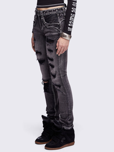 Black washed skinny jeans featuring ripped and stud details, white contrast stitching, embroidered back pocket and raw frayed hems.
