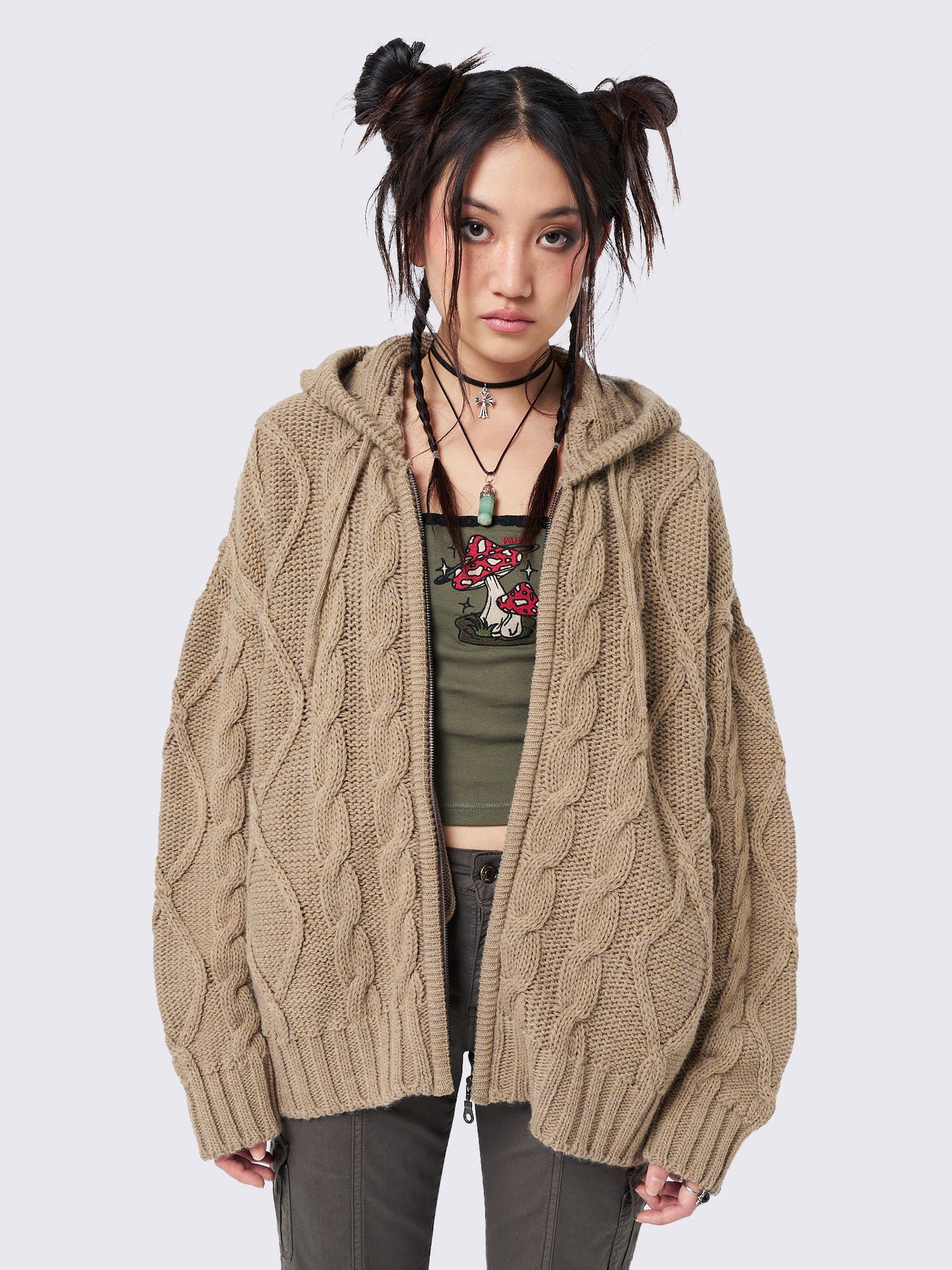 Oversized beige cable knit hooded cardigan with zip fastening and side pockets.