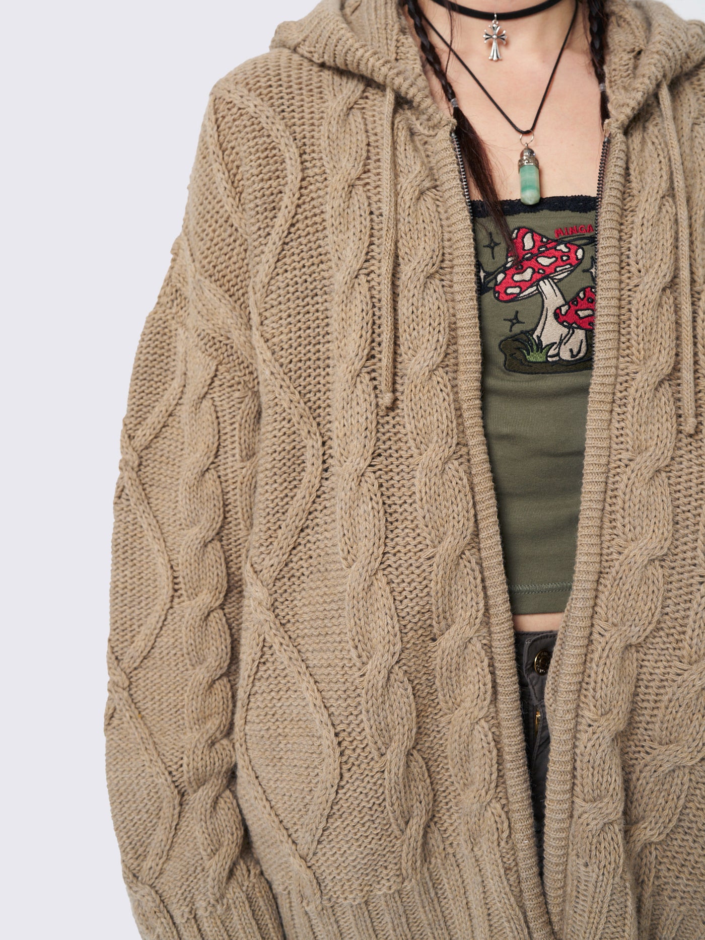 Oversized beige cable knit hooded cardigan with zip fastening and side pockets.