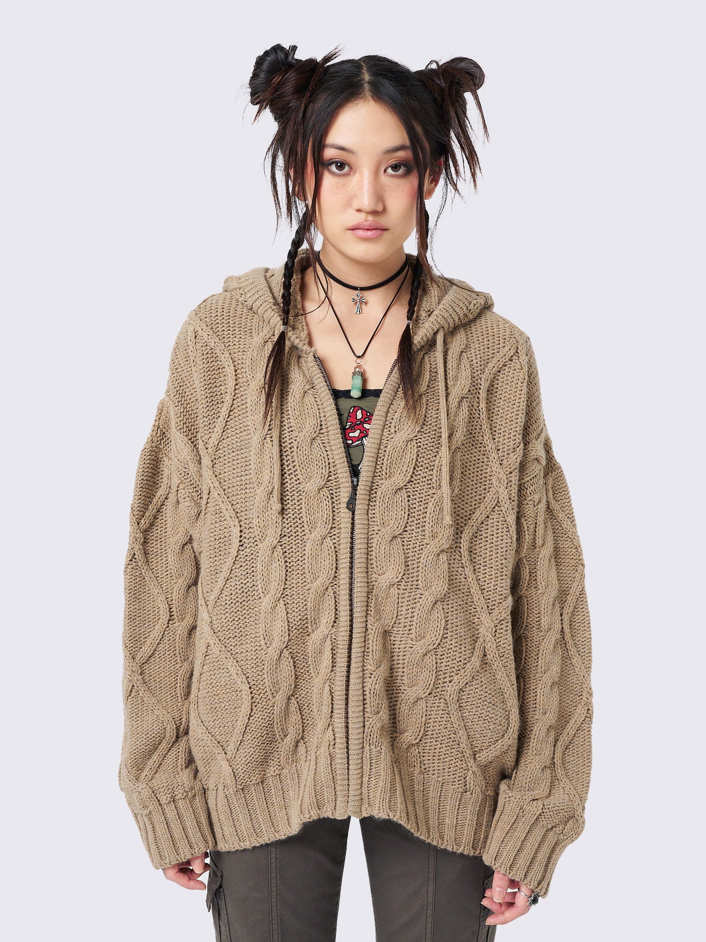 Oversized beige cable knit hooded cardigan with zip fastening and side pockets.