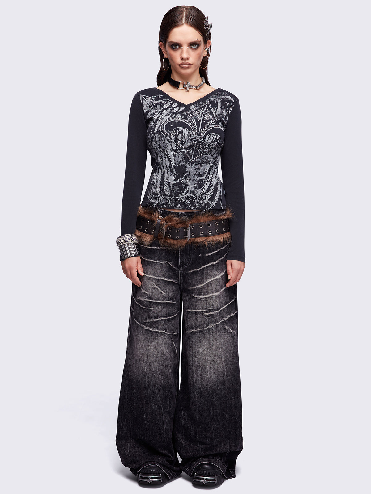 Black washed v-neck ribbed top featuring a fleur-de-lis graphic front print and silver stud details.