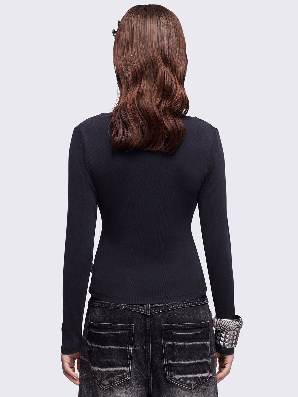 Black washed v-neck ribbed top featuring a fleur-de-lis graphic front print and silver stud details.