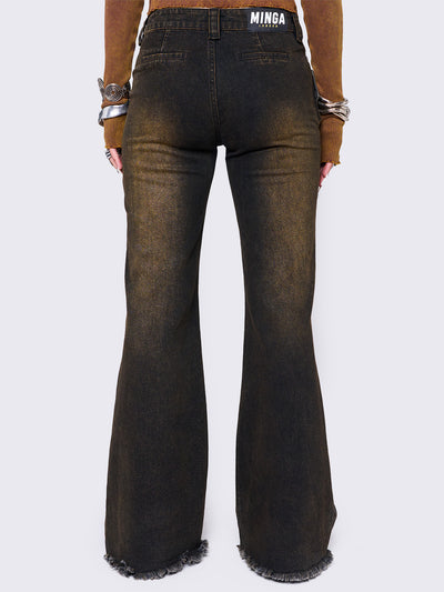 Black flared jeans featuring a honey overdye wash, a chunky buckle belt, distressed seams details and raw frayed hems. 