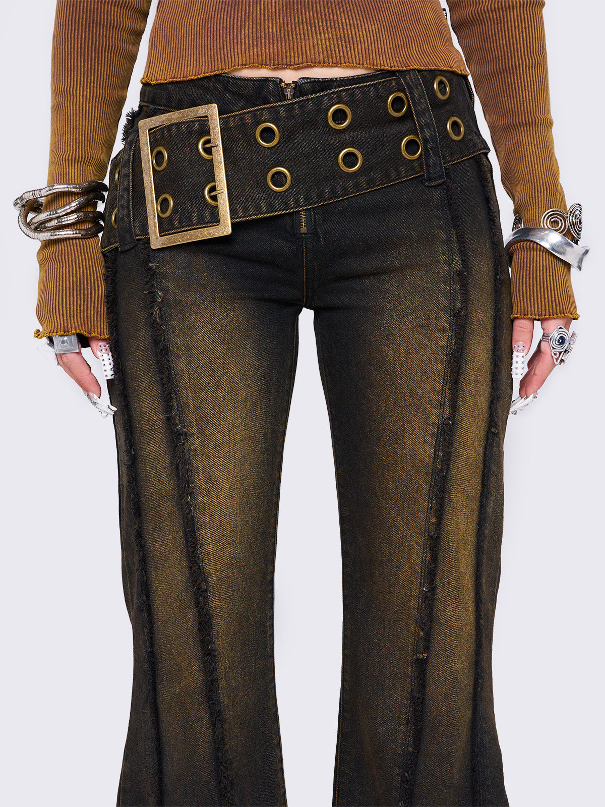 Black flared jeans featuring a honey overdye wash, a chunky buckle belt, distressed seams details and raw frayed hems. 