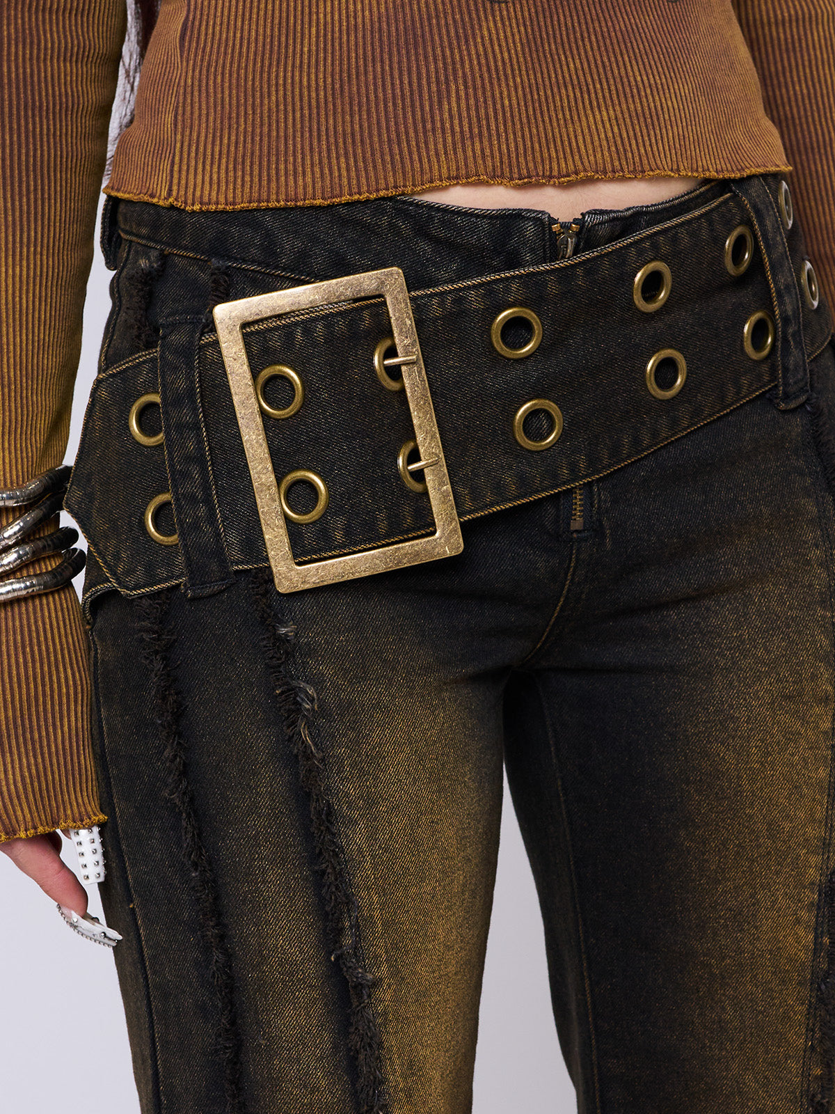 Black flared jeans featuring a honey overdye wash, a chunky buckle belt, distressed seams details and raw frayed hems. 