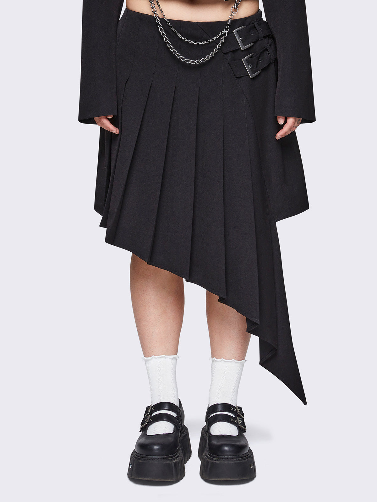 Pleated asymmetric midi skirt in black with double buckle and wrap effect.