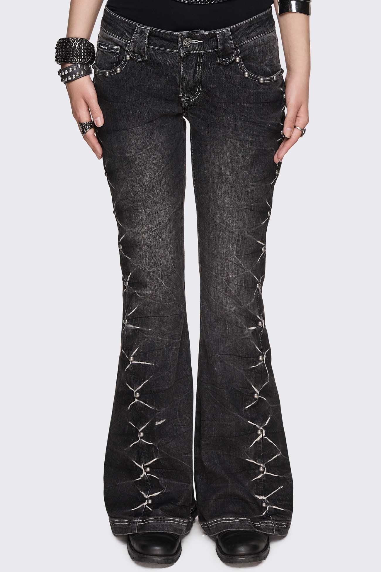 Black washed denim jeans with flared leg, silver studs and white contrast stitching in a grunge Y2K style.