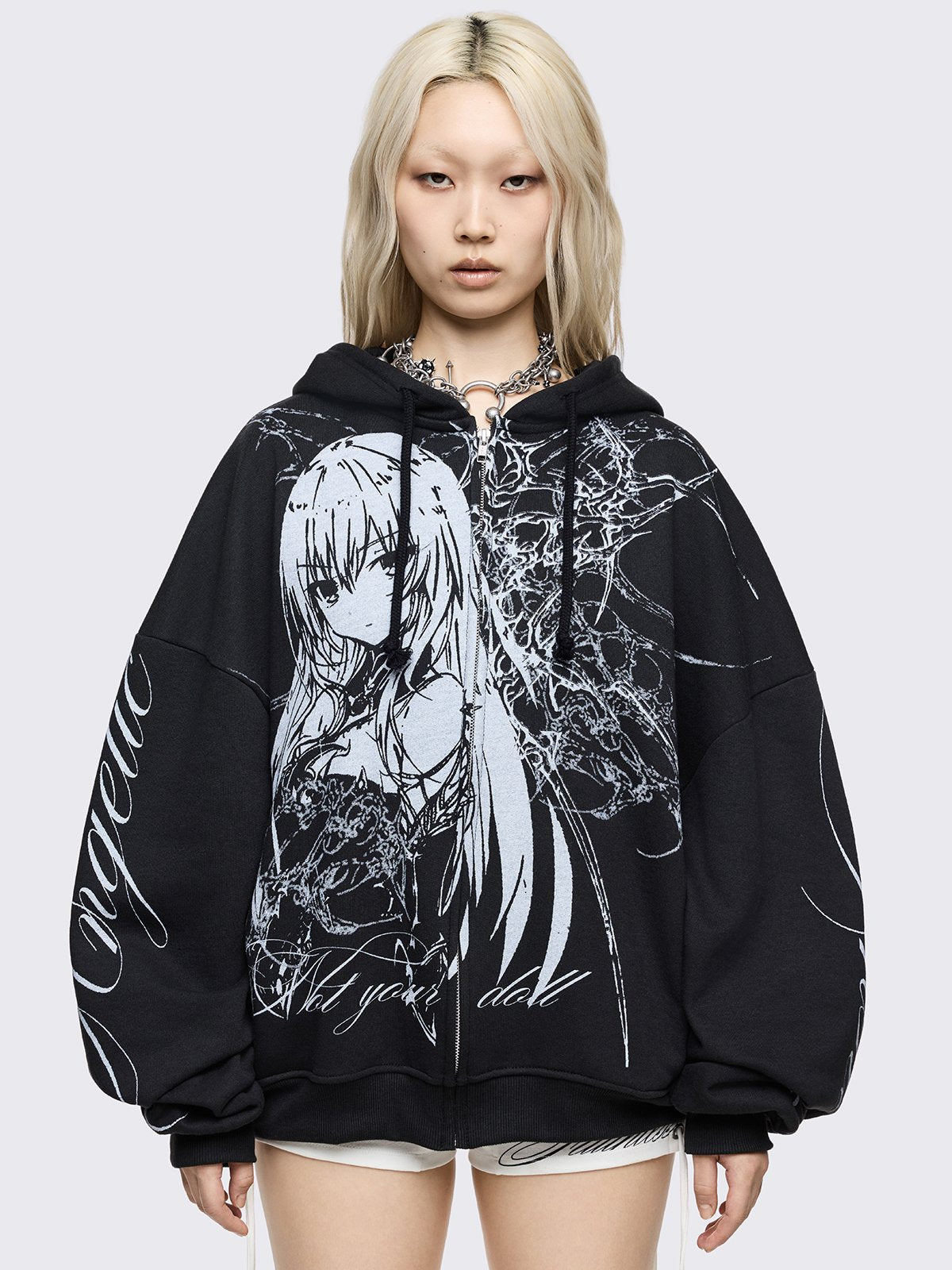 Black oversized zip up hoodie with "Not your doll" anime girl graphic front print and "Angelic insanity" print on sleeves.
