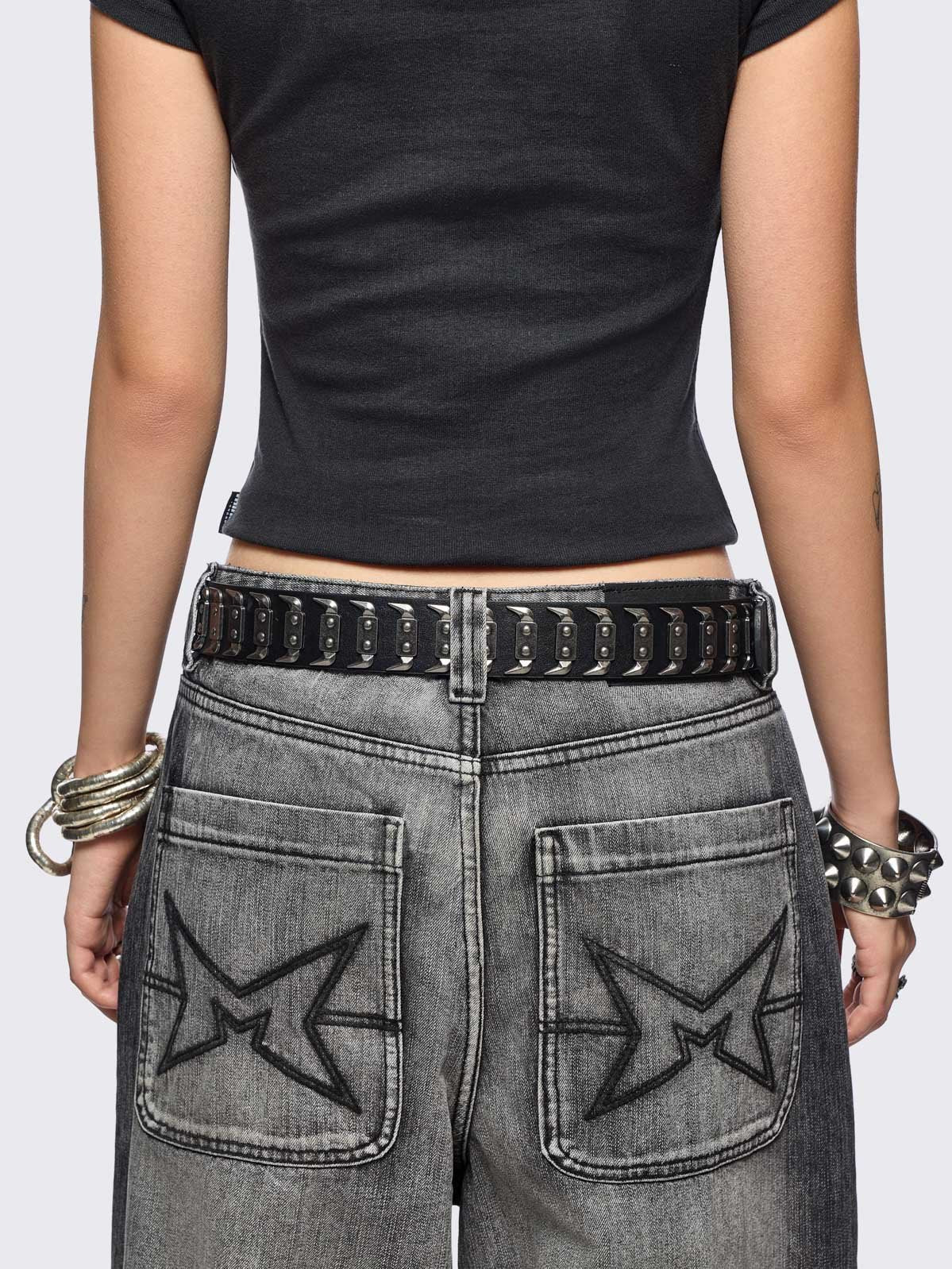 Black faux leather belt with hardware details. 