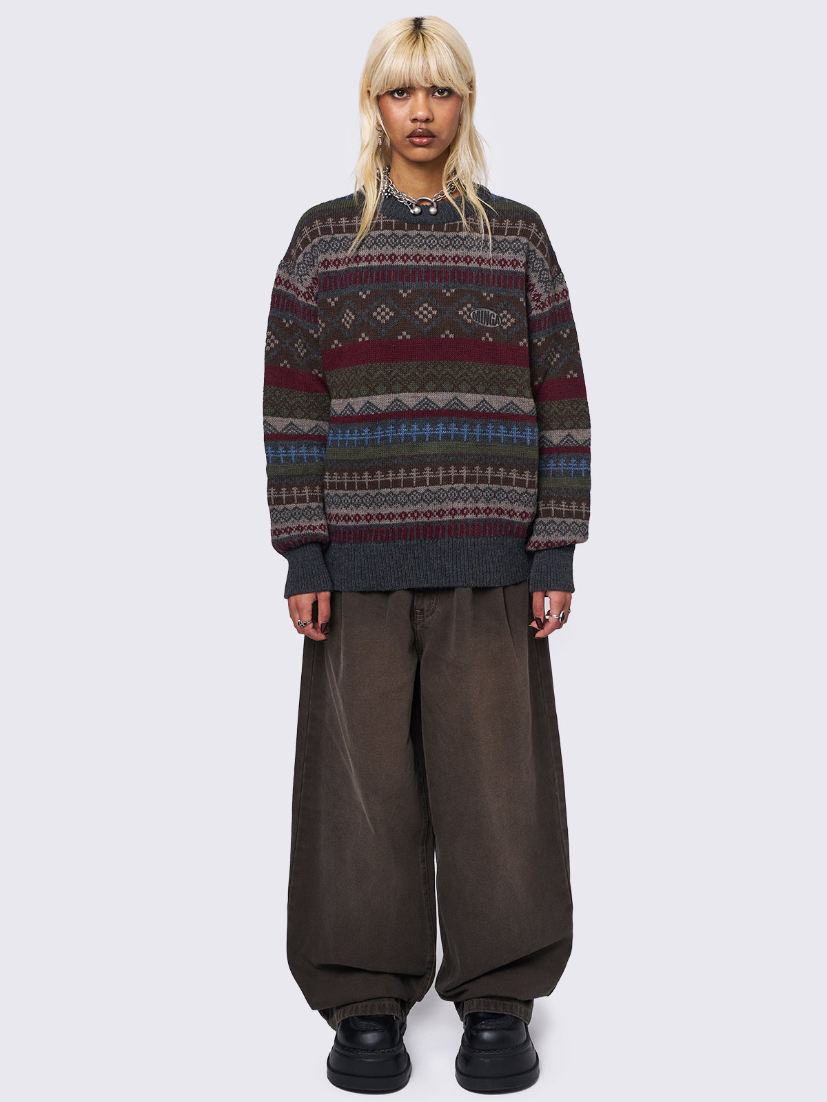 Jacquard knit jumper featuring geometric striped pattern in tones of grey, burgundy, green and blue.