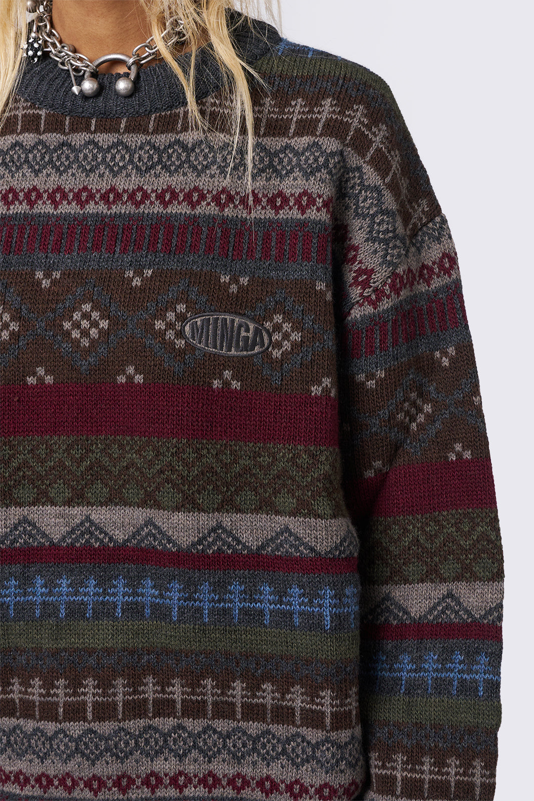 Jacquard knit jumper featuring geometric striped pattern in tones of grey, burgundy, green and blue.