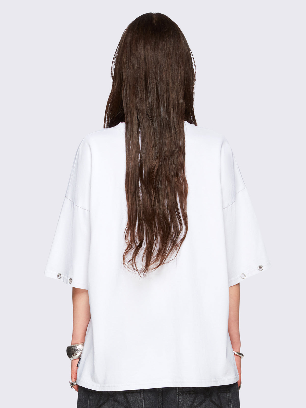 Off-white oversized t-shirt with black kitty graphic front print and eyelet neckline and hem details.