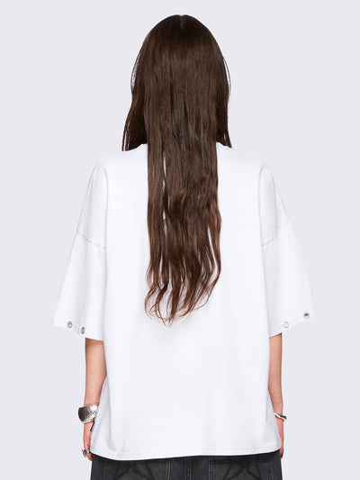 Off-white oversized t-shirt with black kitty graphic front print and eyelet neckline and hem details.