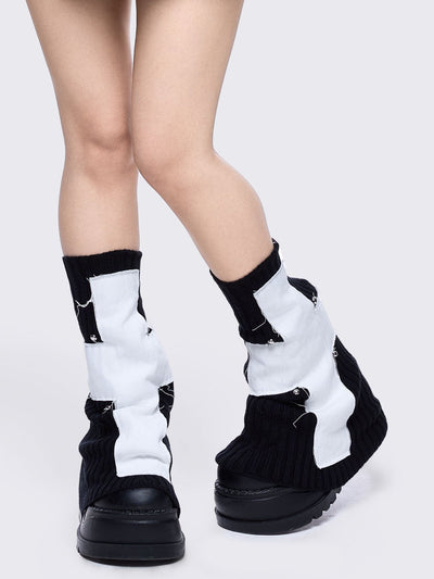 Black knitted flare leg warmers featuring a white chunky cross patch 