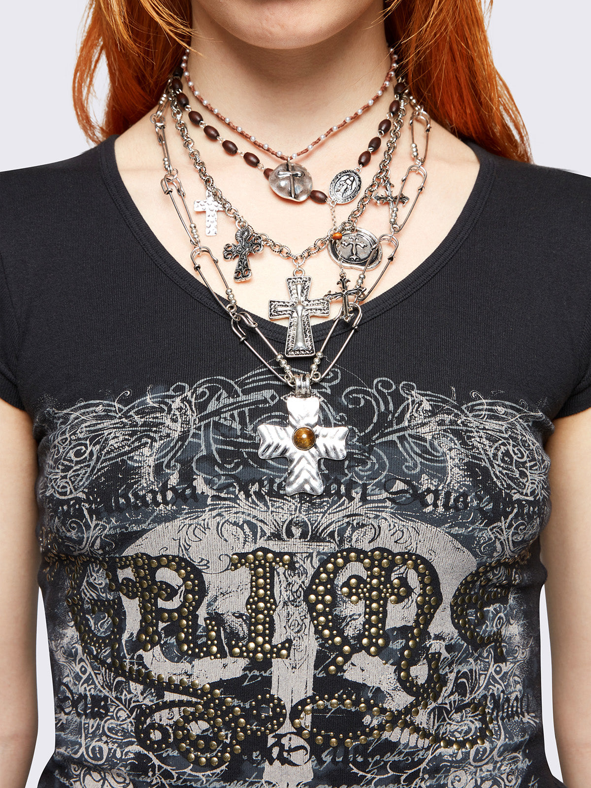 Set of 4 layered necklaces featuring multiple cross pendants: 
Rosary beads, beaded chain, and safety pin chain.