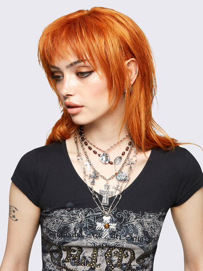 Set of 4 layered necklaces featuring multiple cross pendants: 
Rosary beads, beaded chain, and safety pin chain.