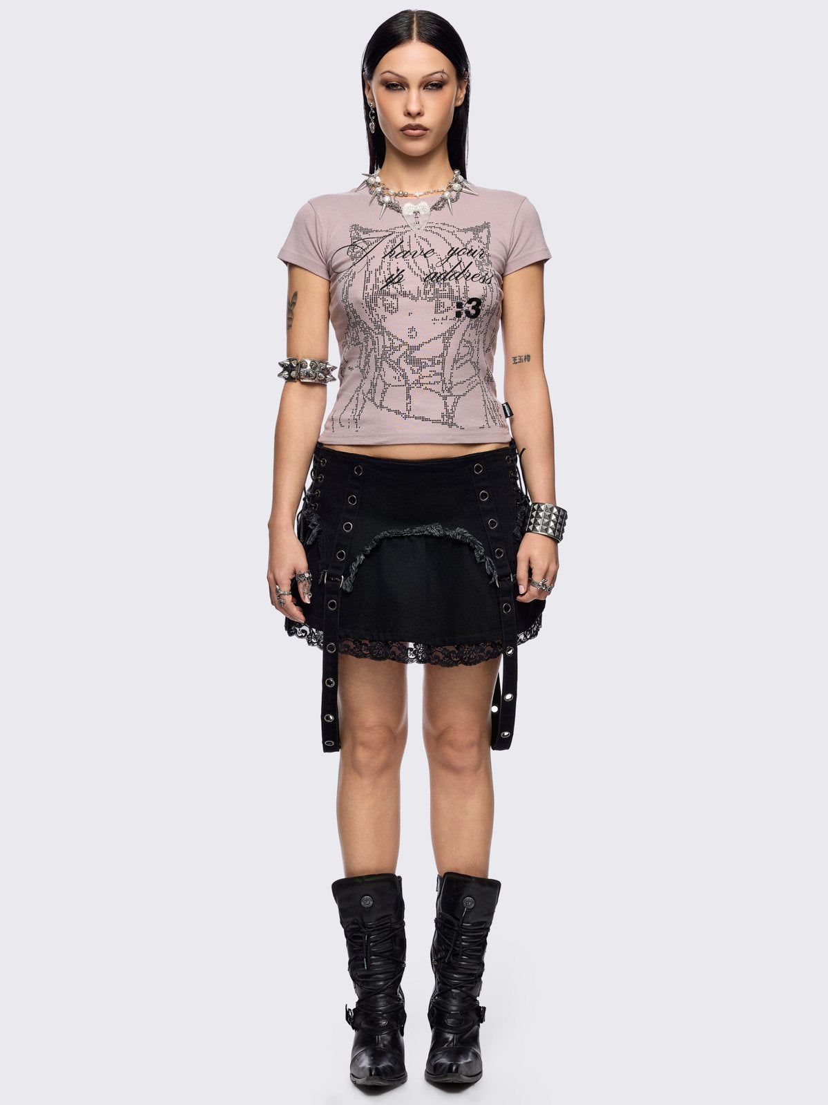 Black denim mini skirt with distressed frayed panels, lace up side details and eyelet straps.