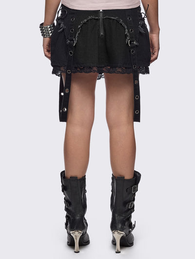 Black denim mini skirt with distressed frayed panels, lace up side details and eyelet straps.