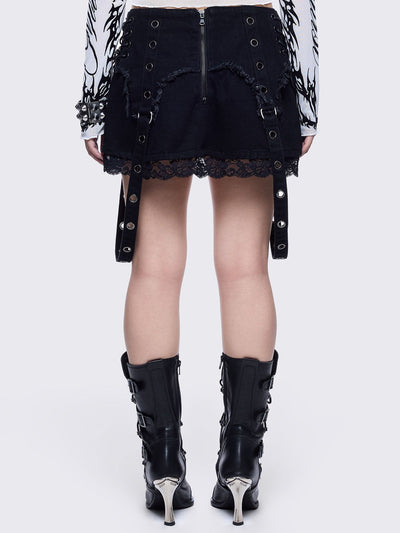 Black denim mini skirt with distressed frayed panels, lace up side details and eyelet straps.