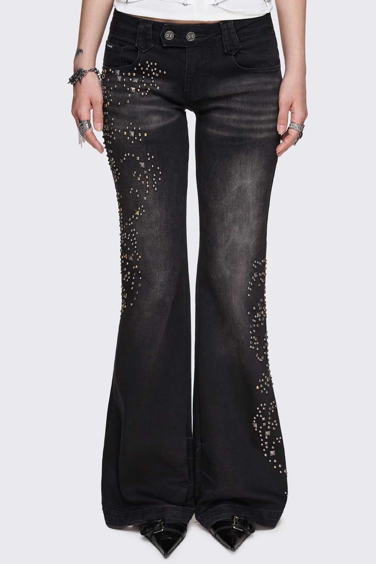 Black washed denim jeans with mixed metal stud detailing, low rise and flared leg in a Y2K grunge style.