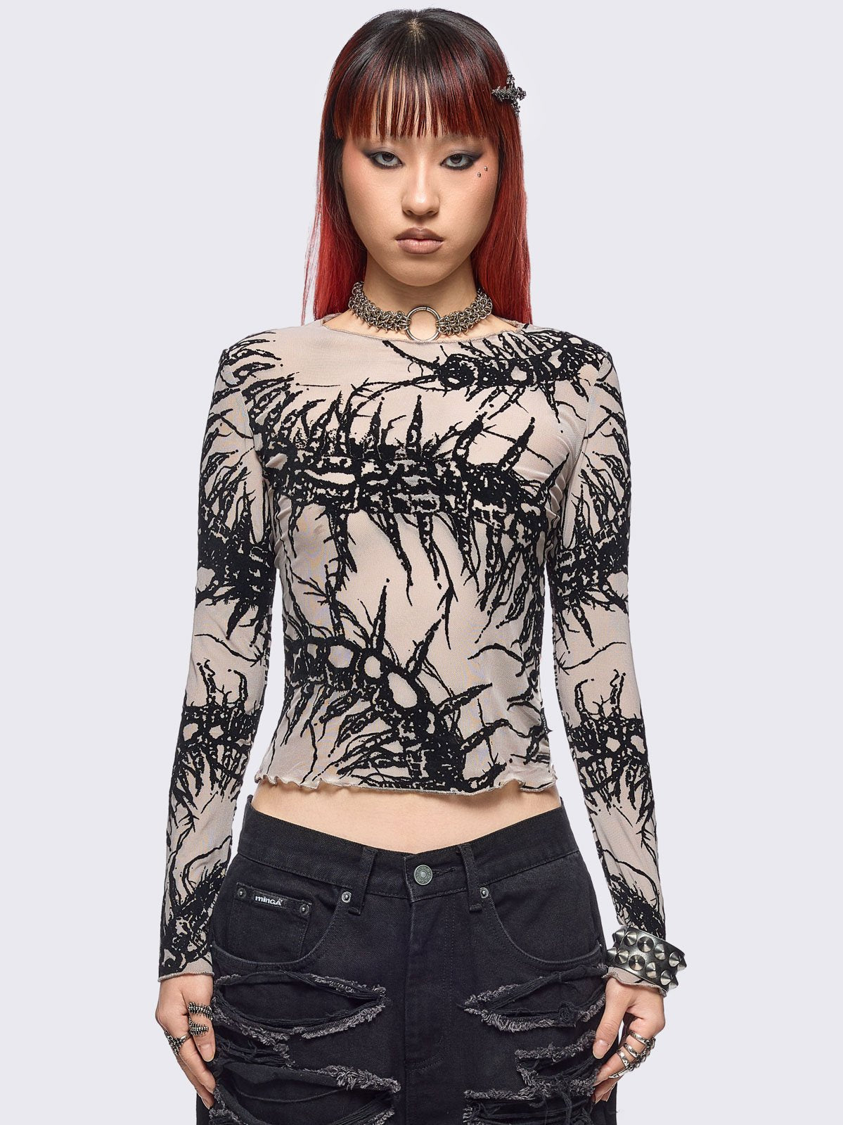 Beige mesh top with black centipede graphic print.