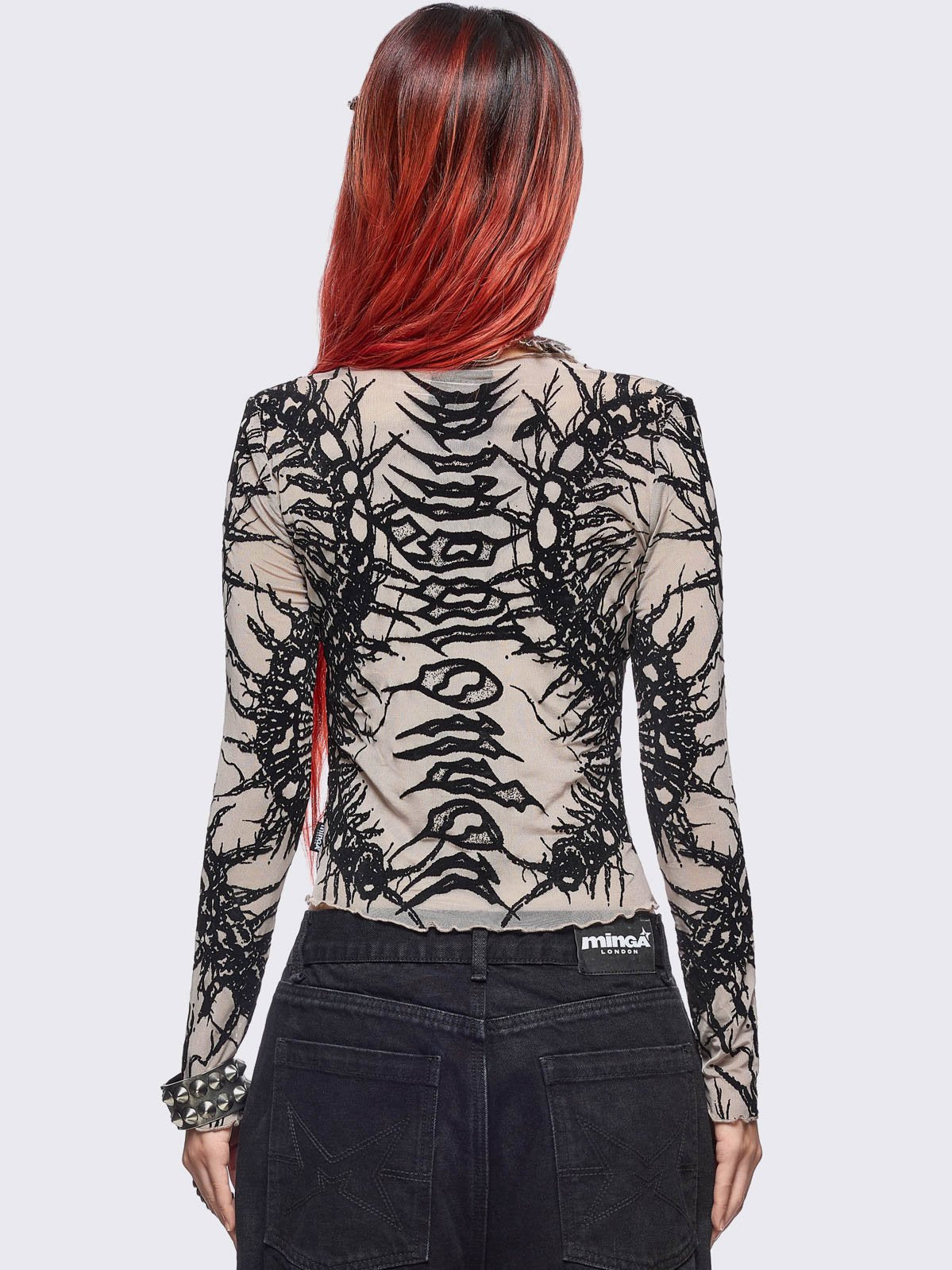 Beige mesh top with black centipede graphic print.