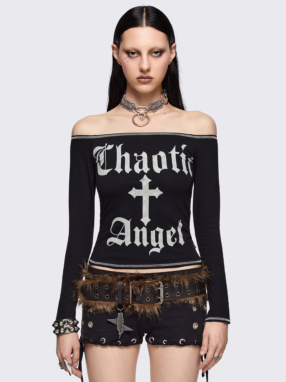 Black off-shoulder top with "Chaotic Angel" cross front print and white contrast stitches.