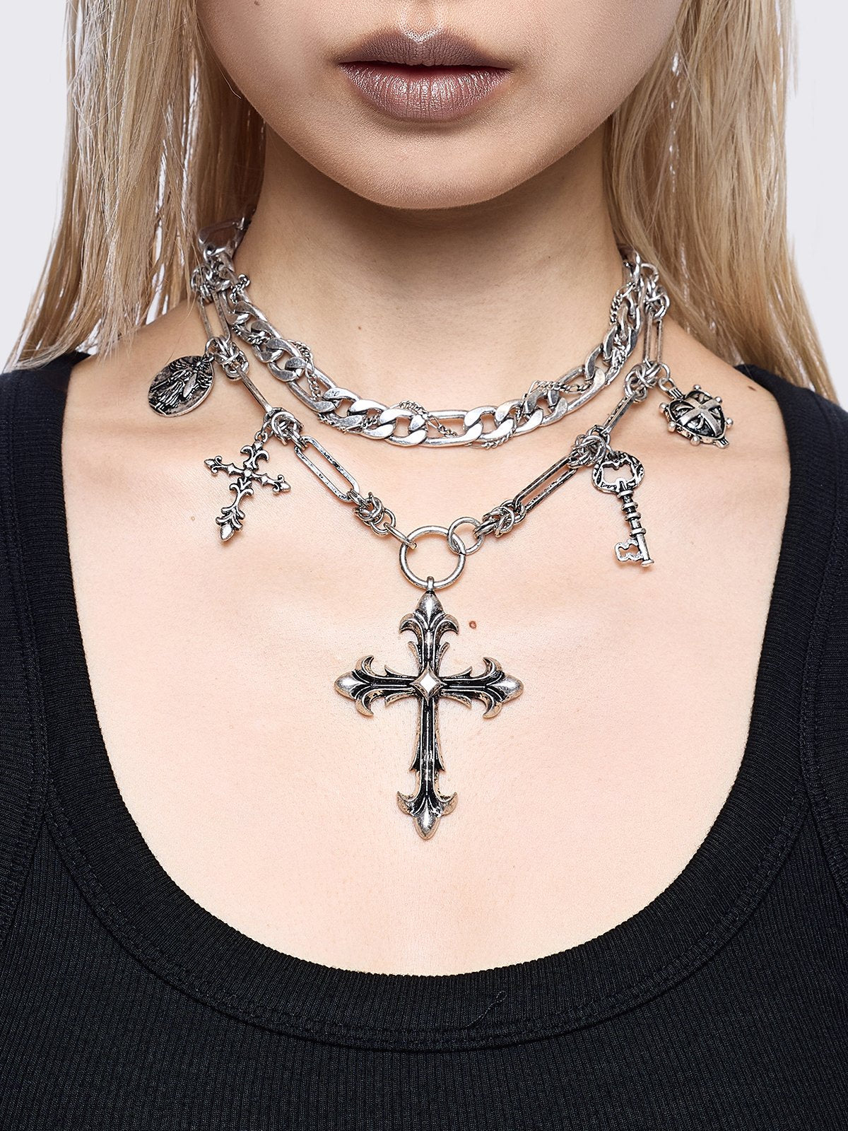Silver chunky layered necklace featuring cross, key and medallion pendants.