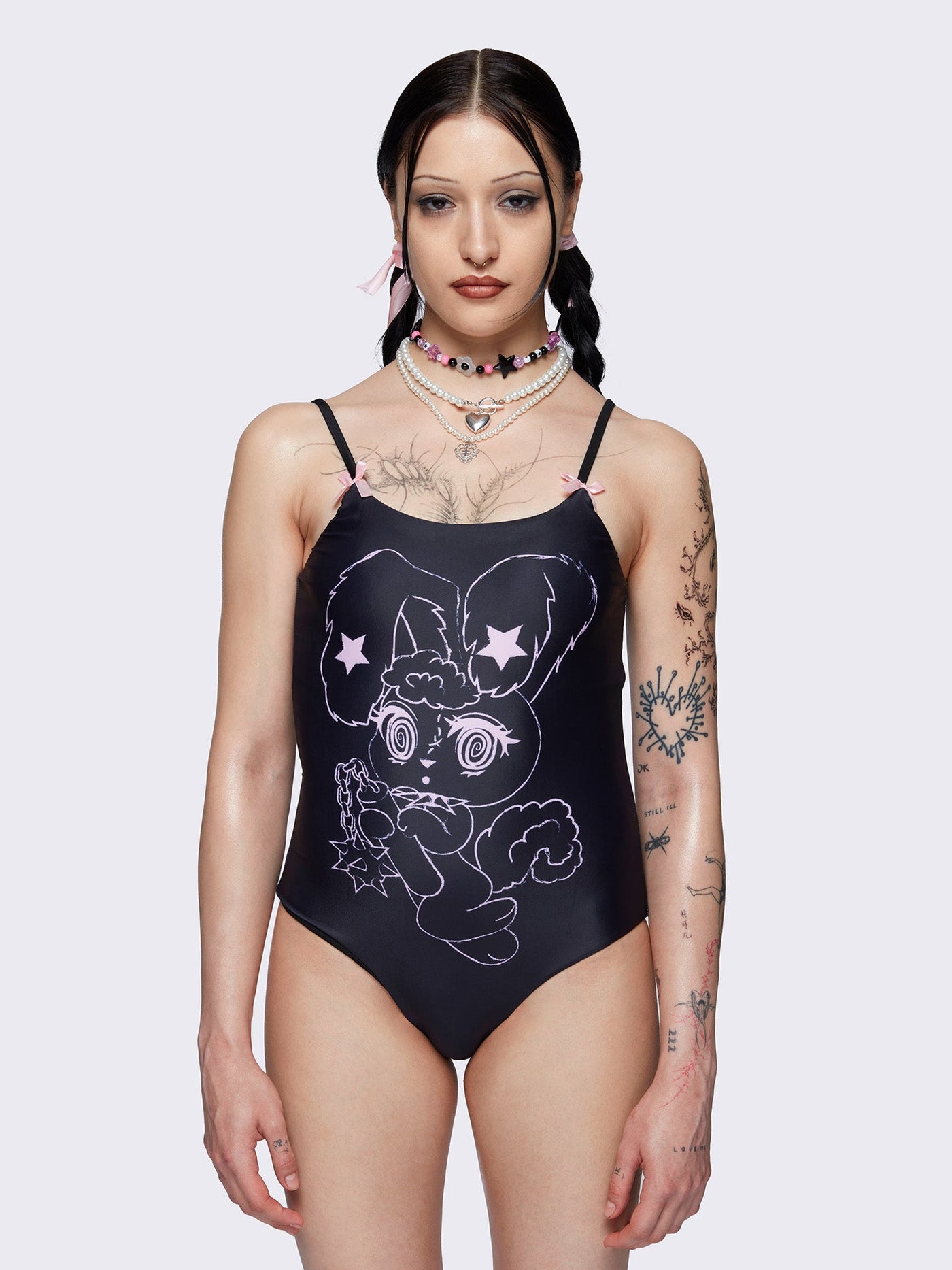 One-piece swimsuit in black with bunny graphic front print and pink laced up at back