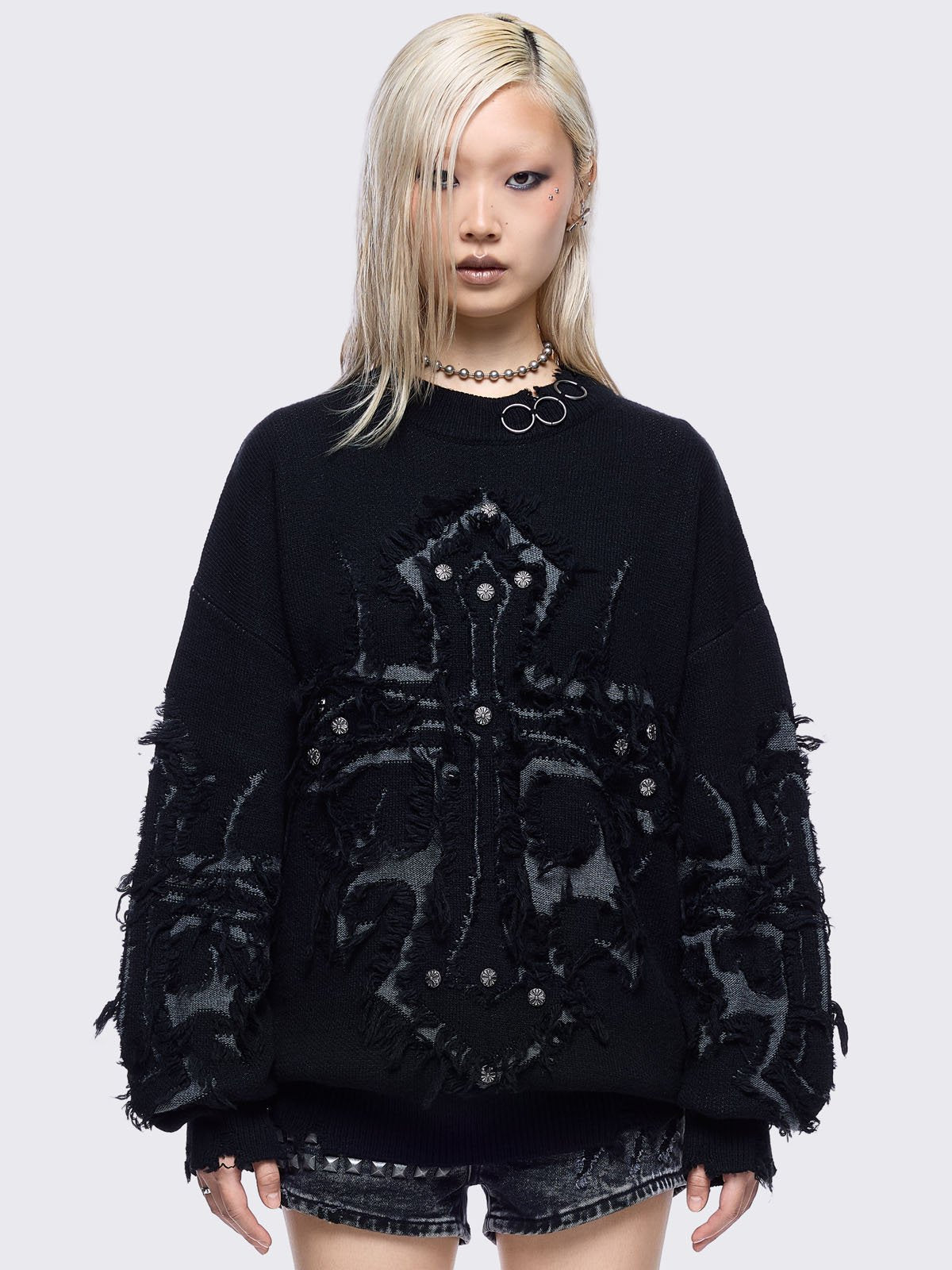 Black knitted jumper featuring frayed crosses design and stud and O-ring details.