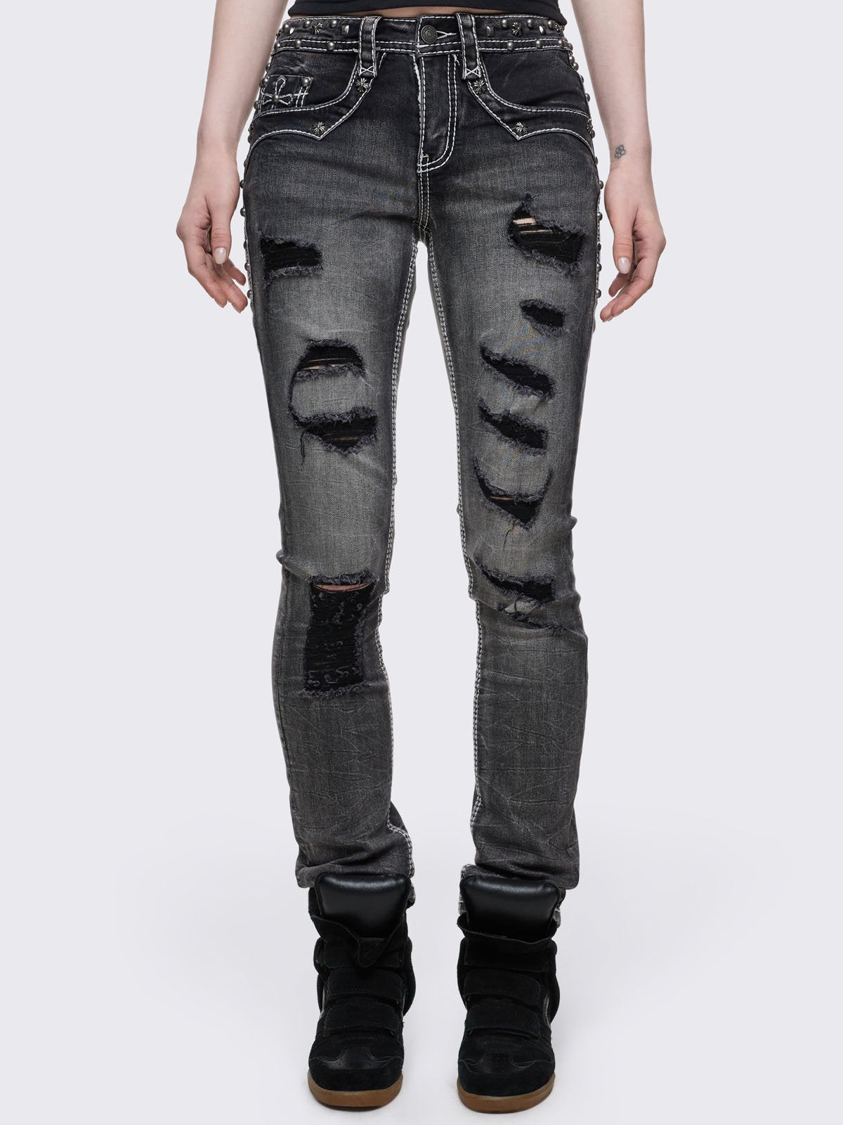 Black washed skinny jeans featuring ripped and stud details, white contrast stitching, embroidered back pocket and raw frayed hems.