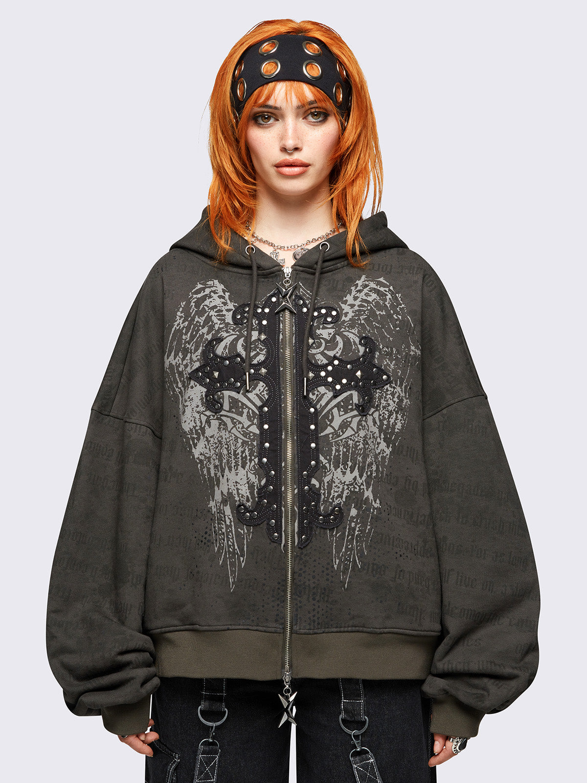 Khaki zip up hoodie jacket featuring a letterings and wings graphic print and cross patch with studded details.