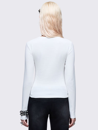 White long sleeve top with black chunky cross with silver studs
