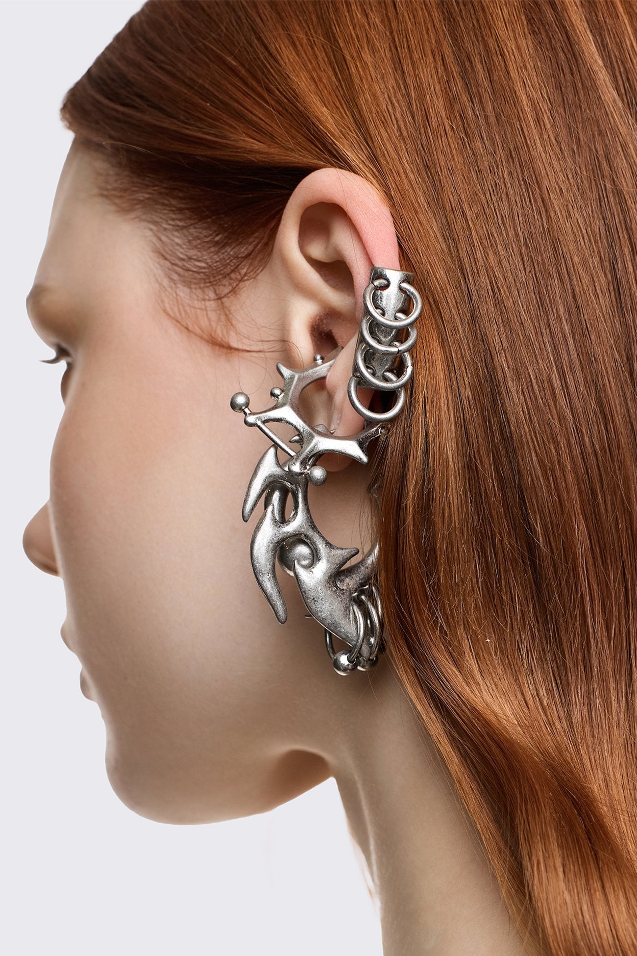 Silver zinc earring set with chunky layered rings and sigilism shapes in an oxidized goth Y2K style.