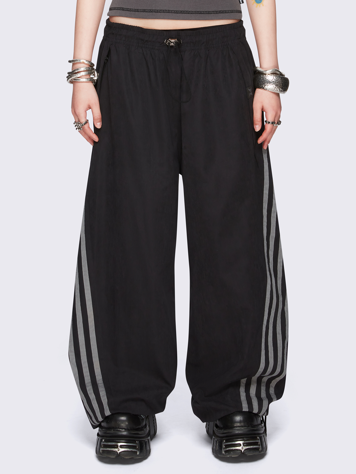 Black parachute pants with grey side stripes. 