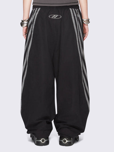 Black parachute pants with grey side stripes. 