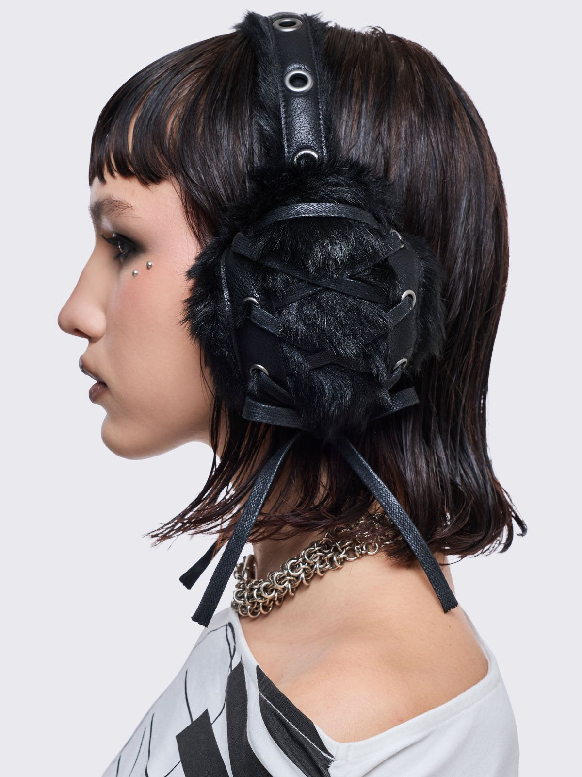 Black faux fur earmuffs and silver eyelet and lace up details.